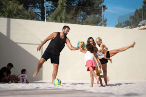 Familia jugando en la playa con balón en un evento deportivo