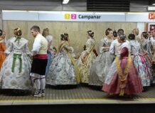Grupo de personas vestidas con trajes tradicionales en una estación de metro.
