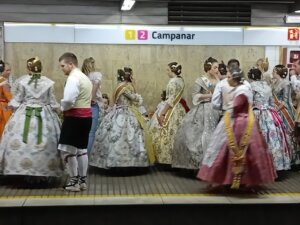 Grupo de personas vestidas con trajes tradicionales en una estación de metro.