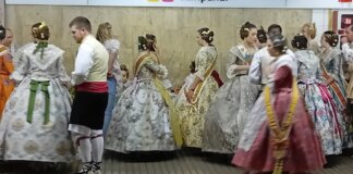 Grupo de personas vestidas con trajes tradicionales en una estación de metro.