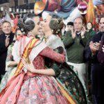 Dos mujeres en trajes tradicionales se abrazan durante la celebración de Fallas.