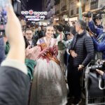 Mujer vestida de fallera celebrando en la calle durante las Fallas 2026.