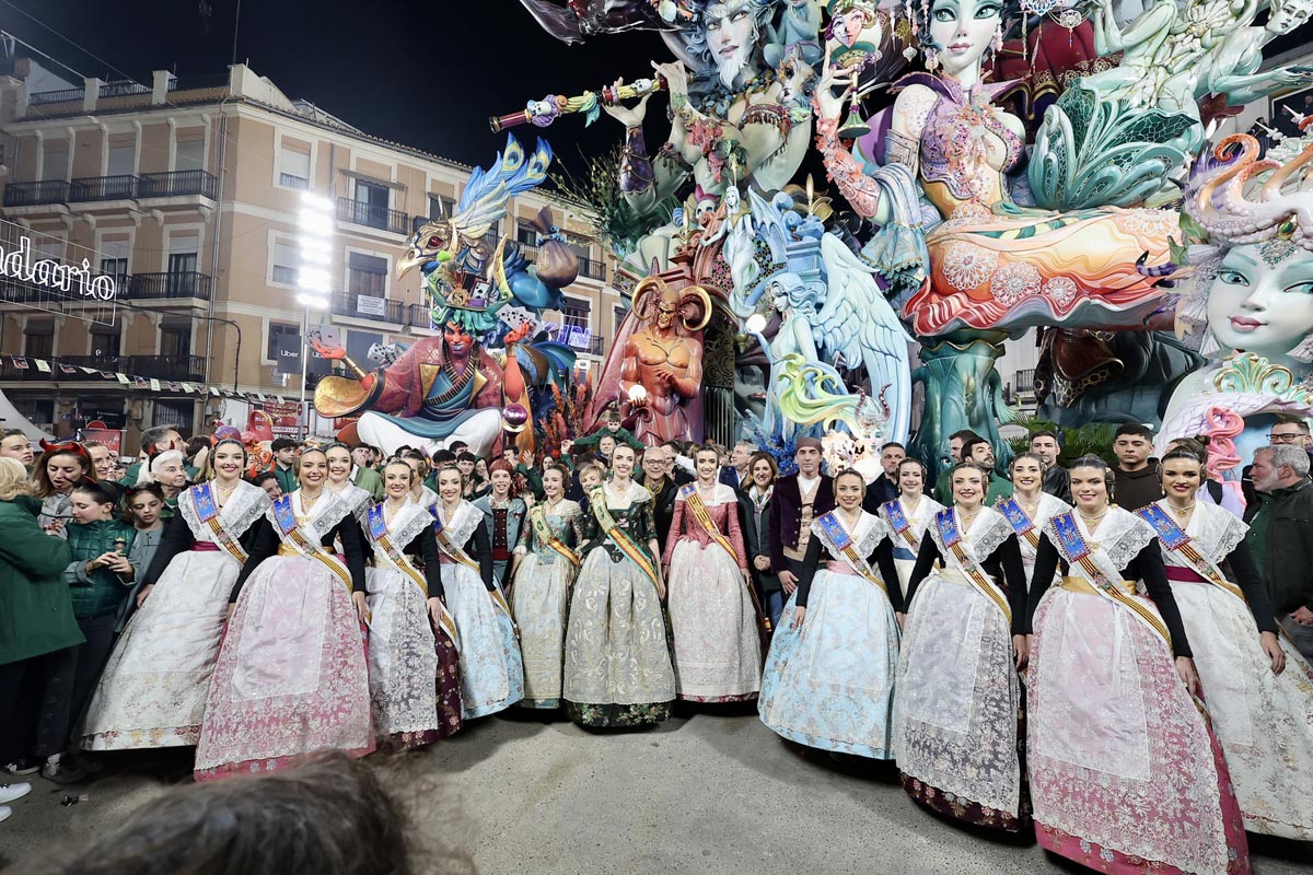 Grupo de personas en trajes tradicionales frente a monumento de Fallas