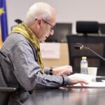 Persona leyendo documentos en una mesa durante un evento de Fallas 2026