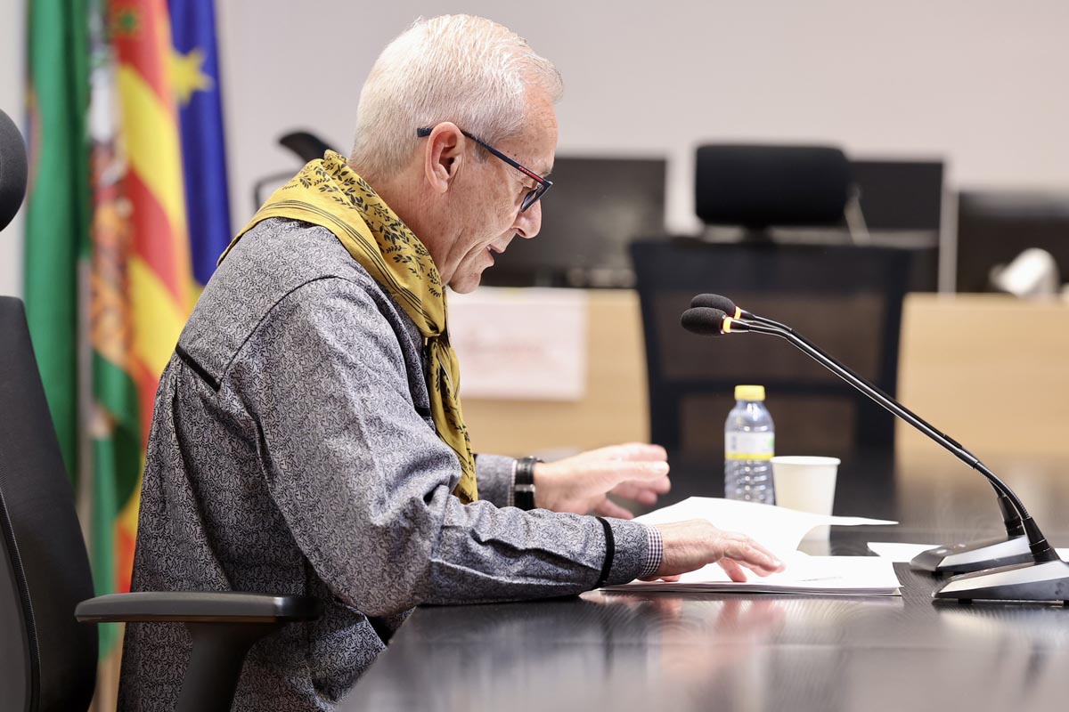 Persona leyendo documentos en una mesa durante un evento de Fallas 2026