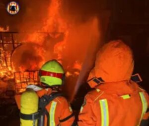 Los bomberos trabajan arduamente para controlar un incendio de camiones.