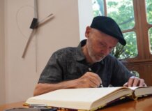 El artista de Meliana aunque afincado en Foios José Antonio Orts, nuevo miembro de la Real Academia de Bellas Artes José Antonio Orts escribiendo en un libro en un ambiente artístico.