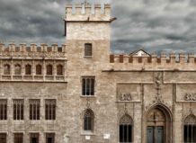 Vista exterior de La Lonja de la Seda en València bajo un cielo nublado