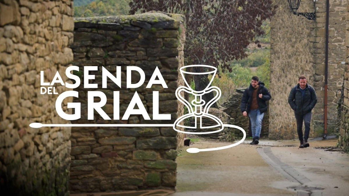 Dos hombres caminando por un camino de piedra en un paisaje natural