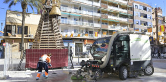 Operario limpiando cerca de una falla en Paiporta durante las fiestas