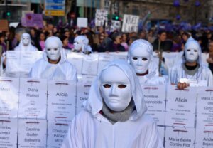 Manifestantes con máscaras blancas en protesta contra la violencia de género en Valencia.