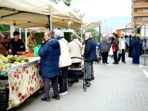Mercado en La Pobla de Farnals con personas comprando productos frescos