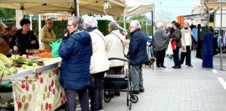 Mercado en La Pobla de Farnals con personas comprando productos frescos