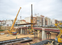 Construcción de una pasarela peatonal en Paiporta con grúas y estructuras metálicas.