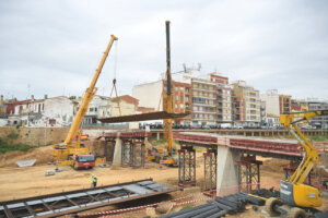 Construcción de una pasarela peatonal en Paiporta con grúas y estructuras metálicas.