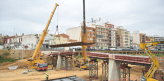 Construcción de una pasarela peatonal en Paiporta con grúas y estructuras metálicas.