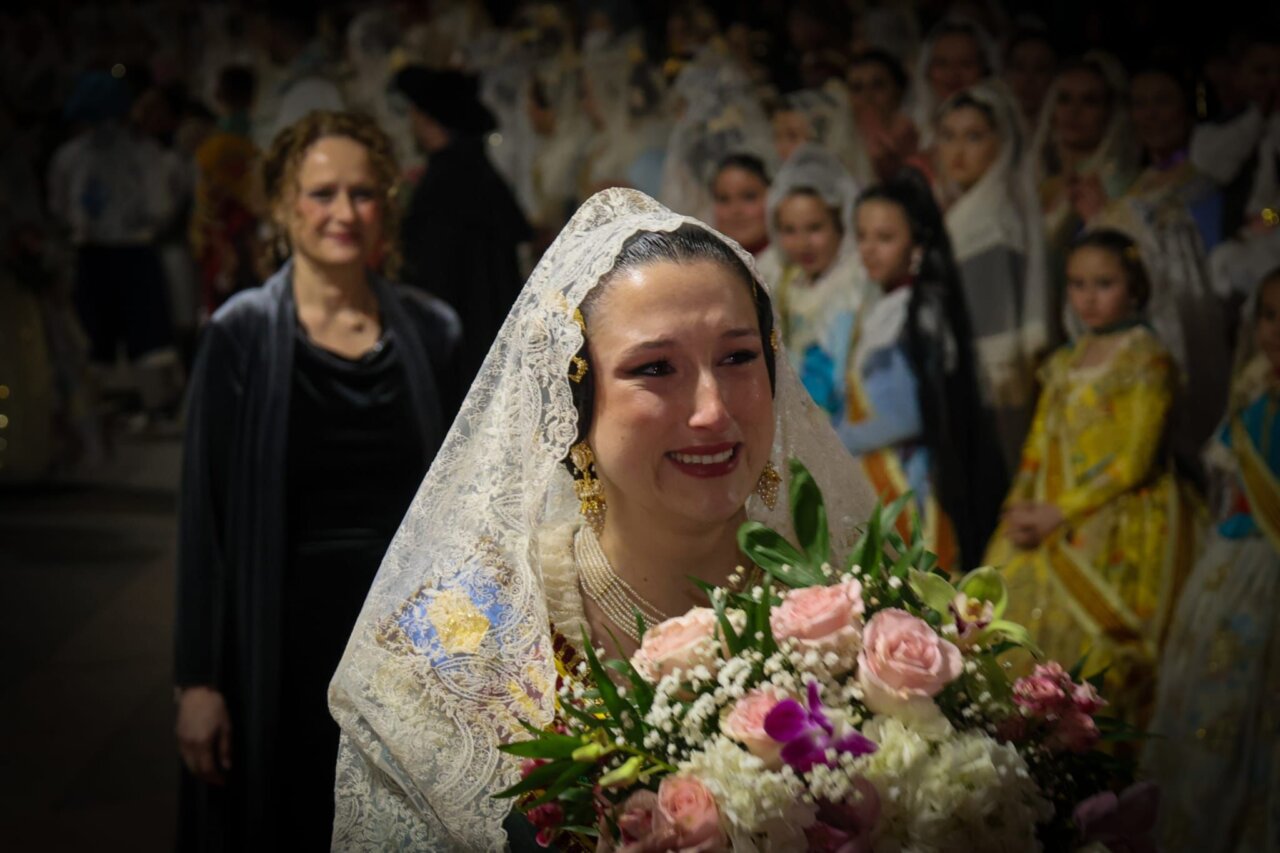Mujer emocionada con flores en una ofrenda en Torrent