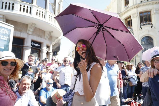 Mujer sonriente con paraguas en evento de pirotecnia