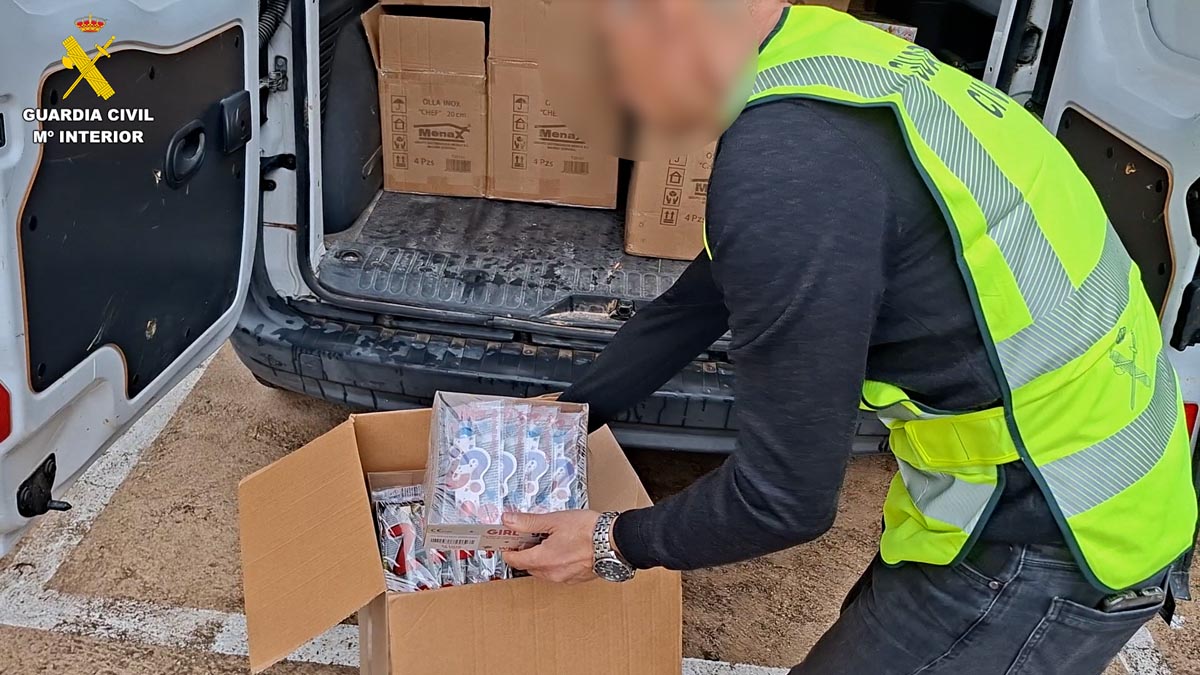 Agente de la Guardia Civil inspeccionando material pirotécnico en un vehículo.