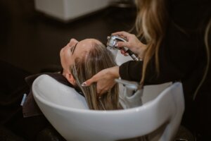 Mujer recibiendo un lavado de cabello en una peluquería profesional
