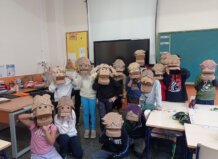 Grupo de escolares con máscaras de cartón en un aula