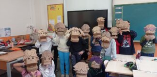 Grupo de escolares con máscaras de cartón en un aula