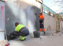 La Escuela de Personas Adultas Enric Valor de Xirivella mejora sus instalaciones con obras de reparación y mantenimiento Trabajadores reparando la pared de la Escuela de Adultos Enric Valor en Xirivella
