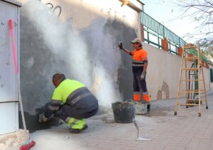 Trabajadores reparando la pared de la Escuela de Adultos Enric Valor en Xirivella