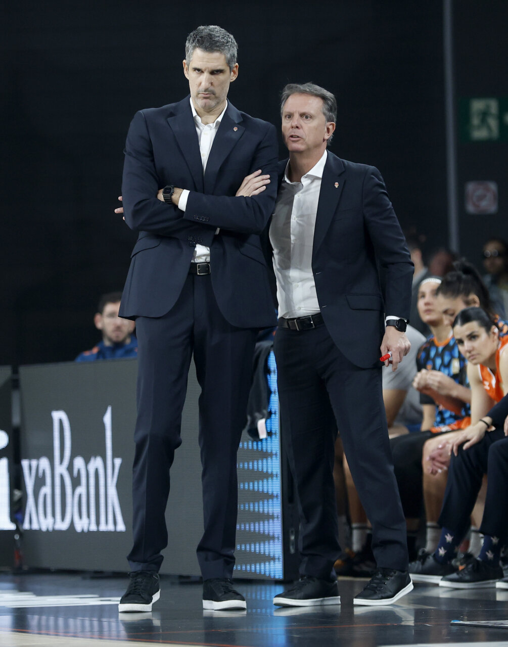 Entrenadores del Valencia Basket discutiendo estrategias durante un partido