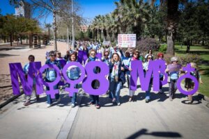 Marcha por la igualdad con mujeres sosteniendo letras en un parque