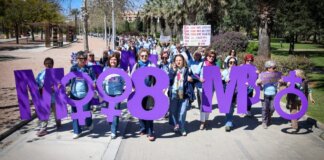 Marcha por la igualdad con mujeres sosteniendo letras en un parque