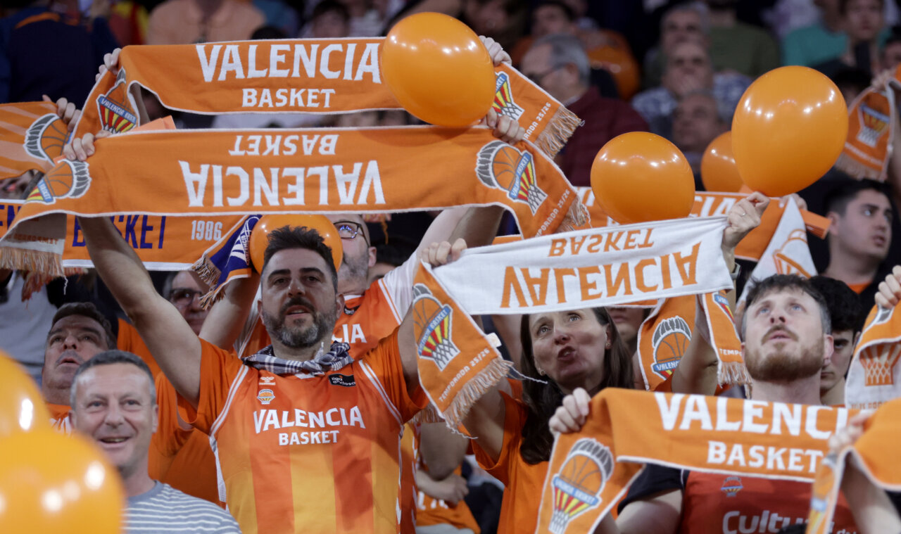 Aficionados del Valencia Basket animando con bufandas y globos naranjas
