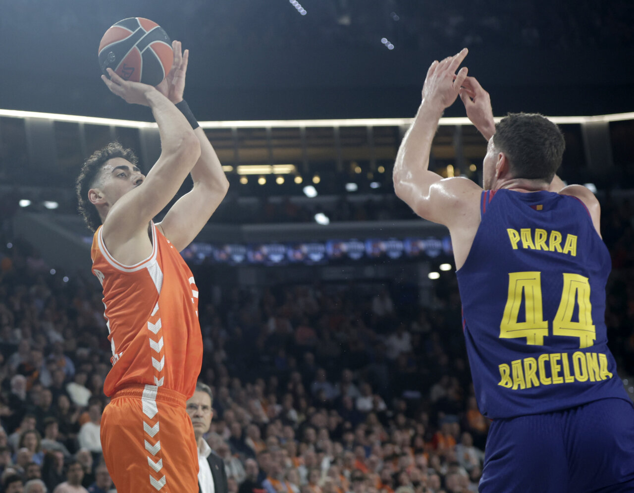 Jugador del Valencia Basket lanzando a canasta mientras es defendido por Parra del Barcelona