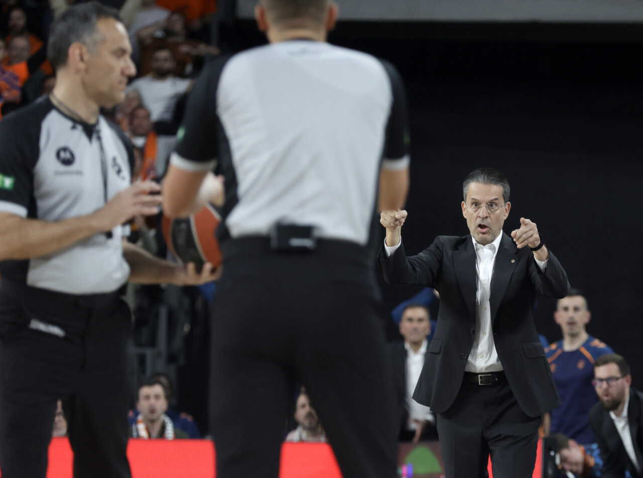 Entrenador de Valencia Basket dirigiendo a su equipo durante un partido emocionante.