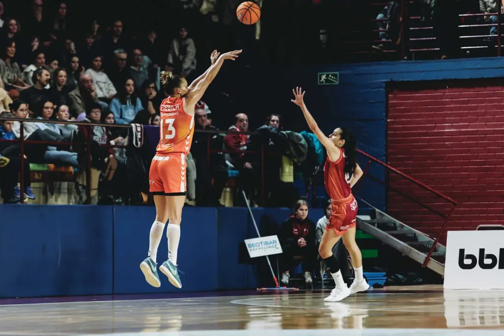 Jugadora del Valencia Basket lanzando a canasta en un partido emocionante