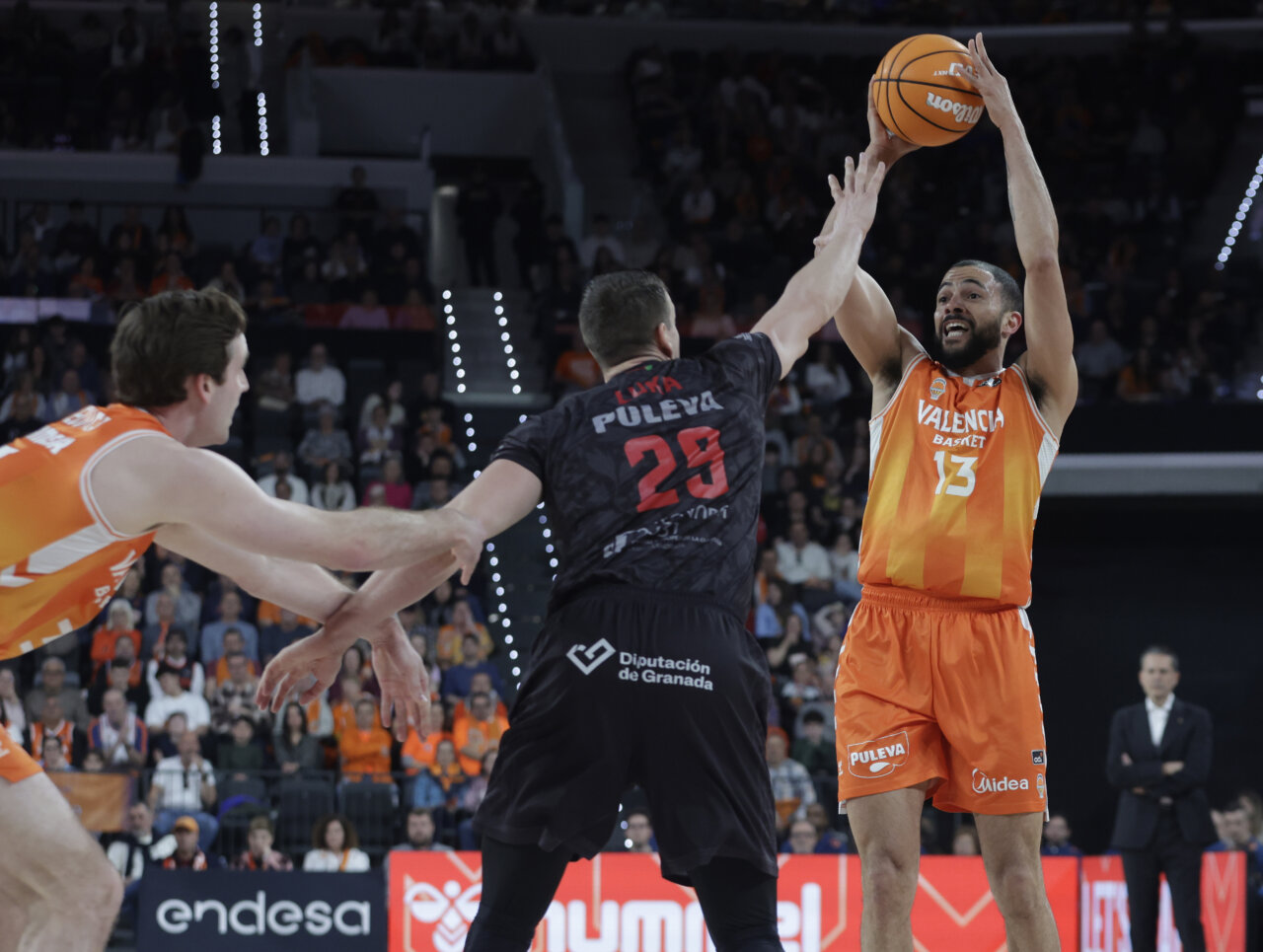 Jugadores de Valencia Basket compiten contra Covirán Granada en un partido de baloncesto.