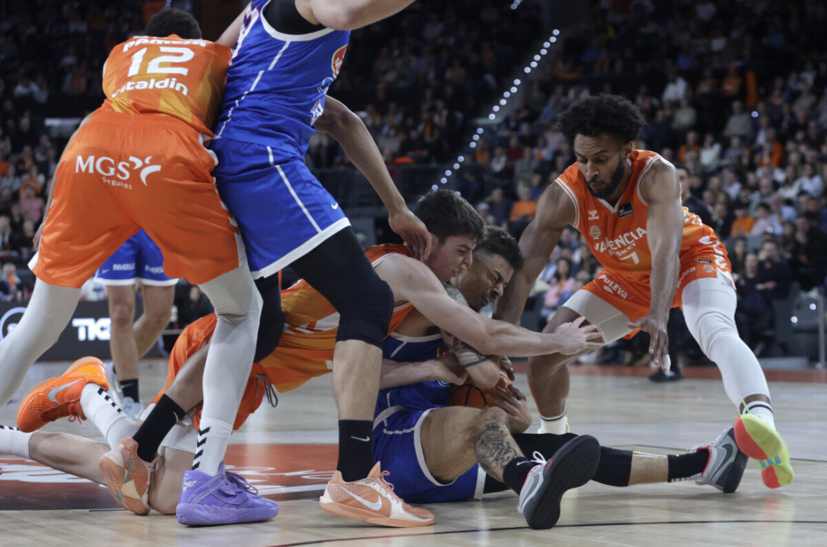 Jugadores de Valencia Basket y UCAM Murcia luchan por el balón en el Roig Arena.