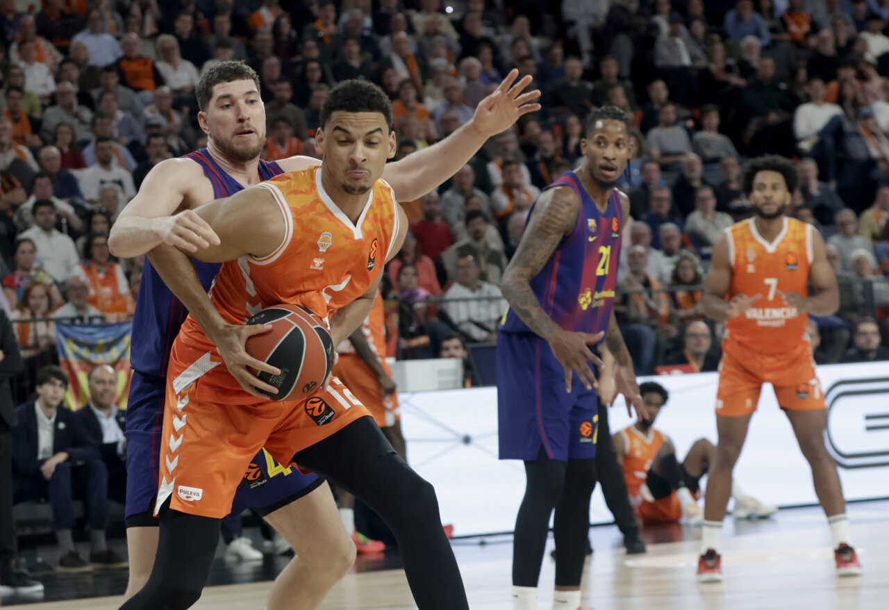 Jugadores de baloncesto del Valencia Basket y FC Barcelona en acción durante un partido