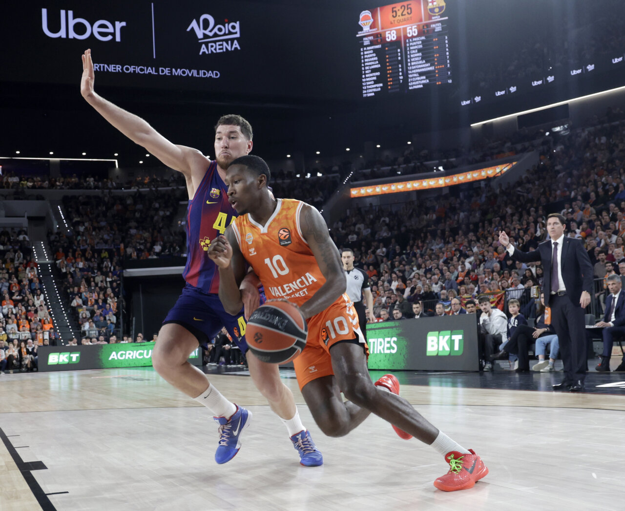 Jugador del Valencia Basket driblando mientras es defendido por un jugador del Barcelona