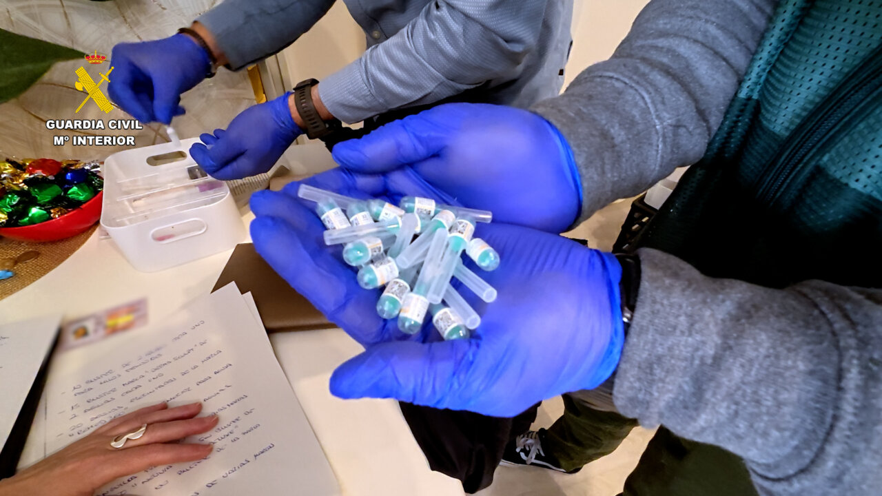 Manos con jeringuillas y viales de toxina botulínica en una operación policial