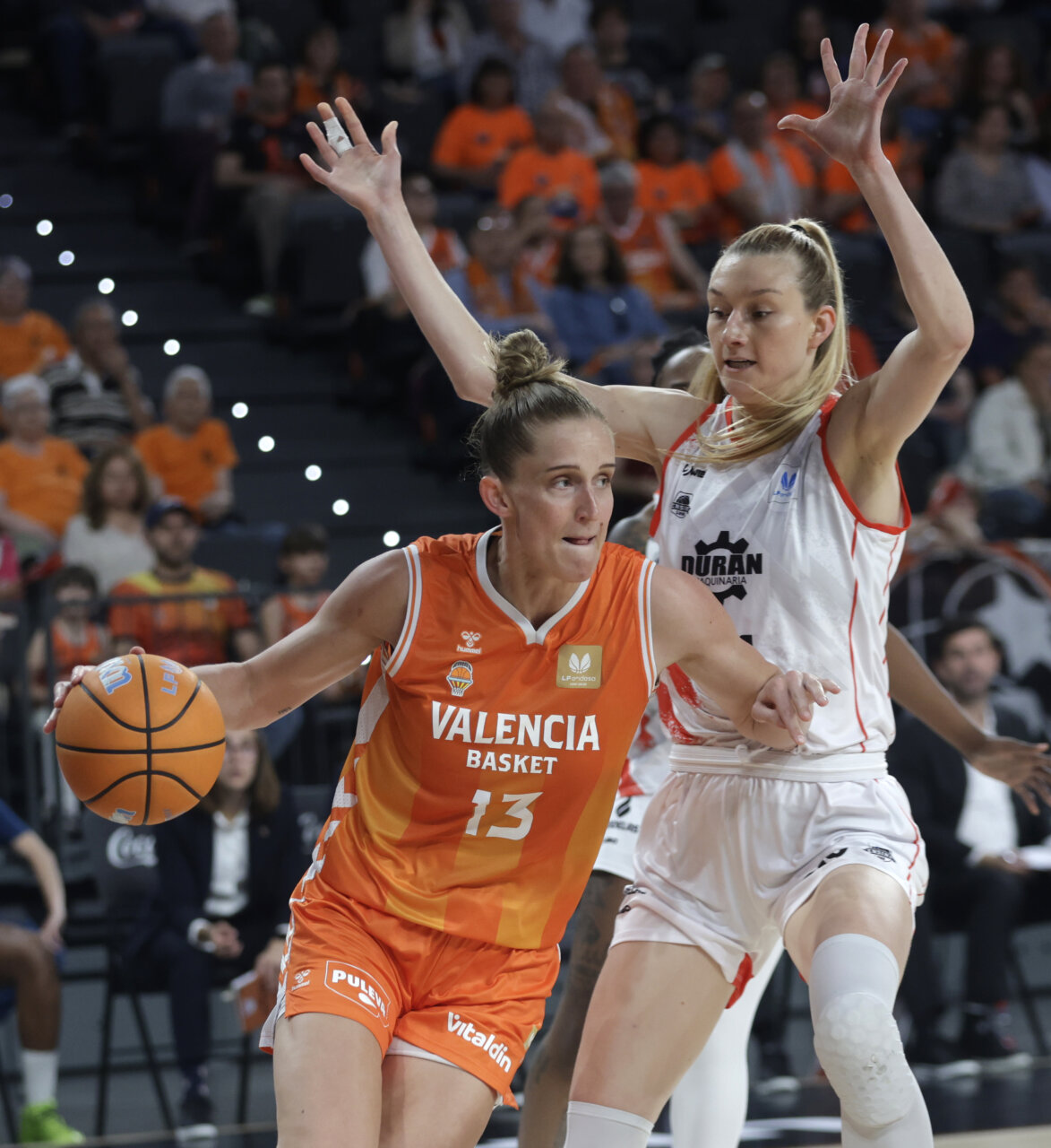 Jugadora de Valencia Basket driblando mientras es defendida por rival del Ensino.