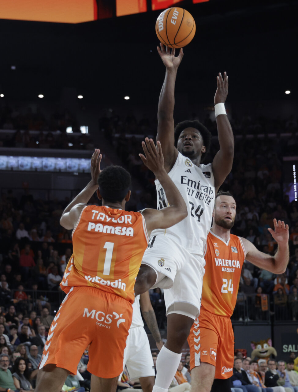 Jugador del Real Madrid lanza a canasta durante un partido de baloncesto.