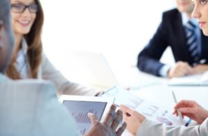 Reunión de asesoría empresarial con gráficos y tablet