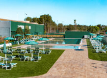 Vista de la primera piscina climatizada exterior en Valencia con tumbonas y sombrillas