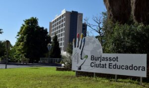 Cartel de Burjassot Ciutat Educadora con un edificio al fondo