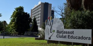 Cartel de Burjassot Ciutat Educadora con un edificio al fondo