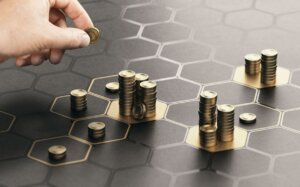 Mano colocando monedas sobre un tablero hexagonal con pilas de monedas
