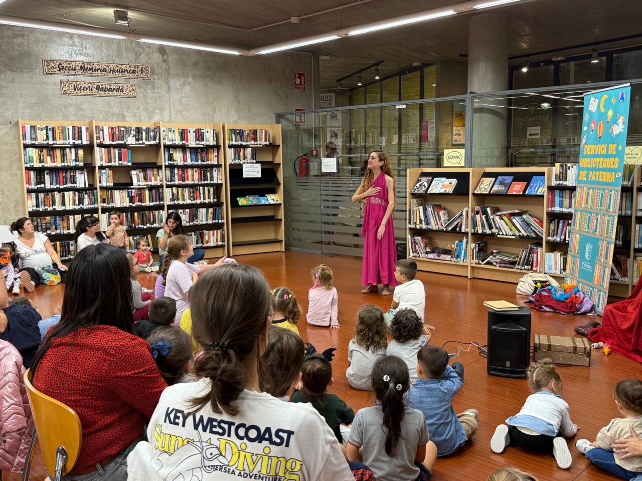 Cuentacuentos en la Cova Gran de Paterna con niños y adultos escuchando.