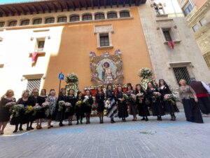 Grupo de mujeres vestidas de negro con flores en la festividad de Sant Vicent Ferrer