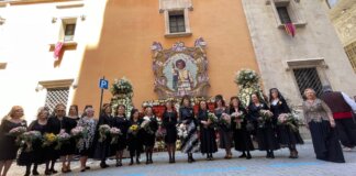 Grupo de mujeres vestidas de negro con flores en la festividad de Sant Vicent Ferrer